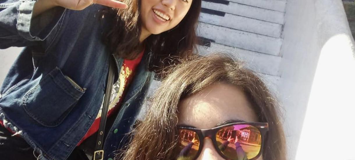 两个学生微笑,摆姿势的照片在一组楼梯画看起来像钢琴键。