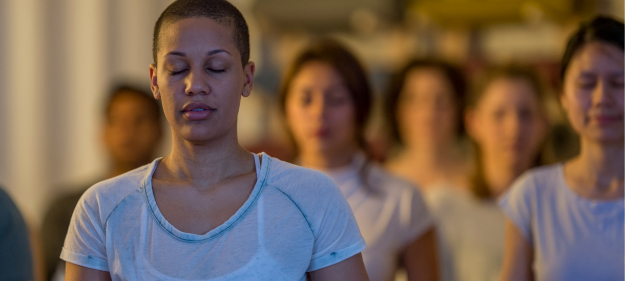 Person in light blue shirt sits contemplative in foreground