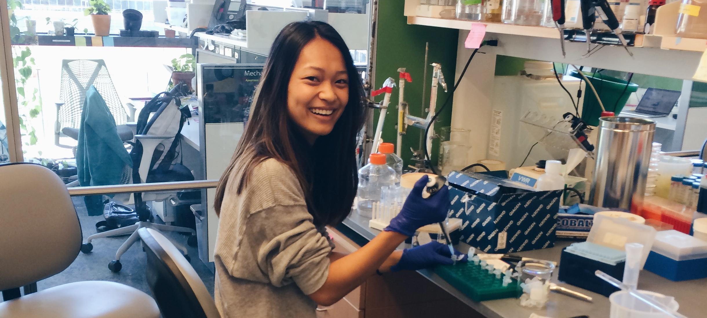 Student sitting at lab desk smiling
