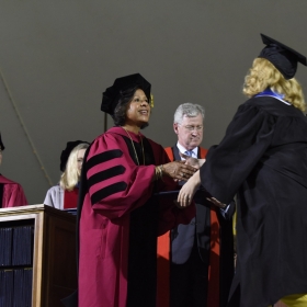 A photo of President Johnson awarding a diploma to a student