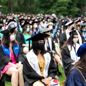 学生们坐在毕业典礼,戴着面具