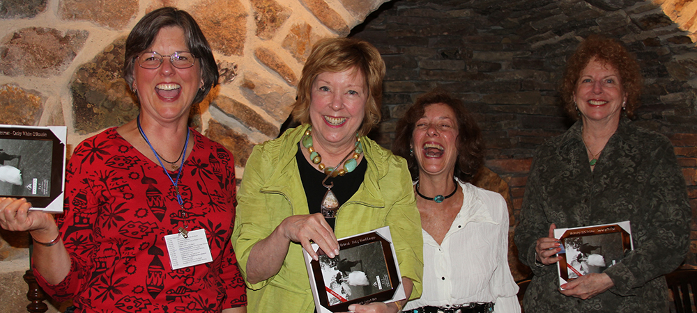 贝特西和three other women holding new picture frames and smiling