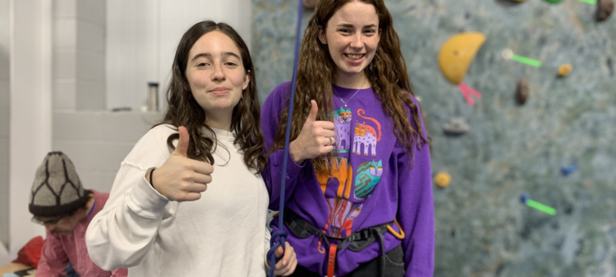 Students posing in front of the climbing wall