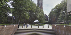 亚博永久官网韦尔斯利学院的盖伦石头塔朱厄特大厅的台阶的前景和两个学生走路。