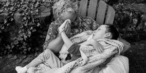 A photo of Maria Kefalas sitting in a chair with her daughter Cal on her lap.